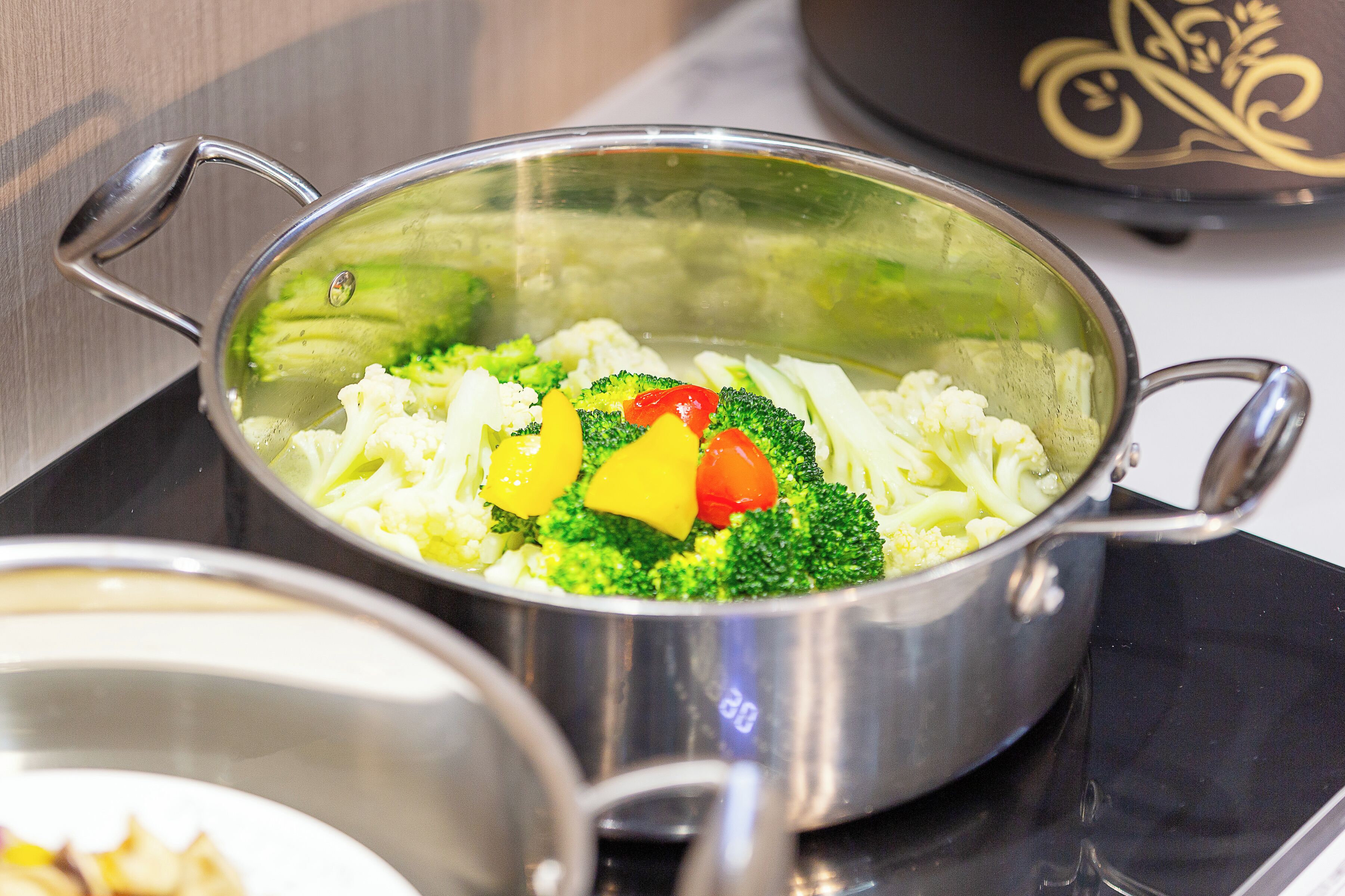 A stainless steel pot with handles on a stovetop.