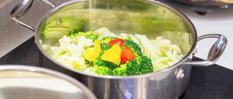 A stainless steel pot with handles on a stovetop.