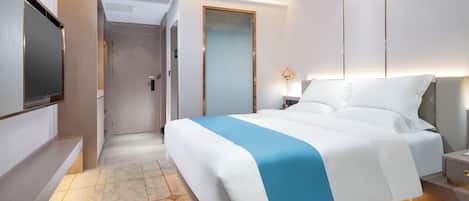 Una habitación de hotel moderna con una cama grande, mesitas de noche, un televisor de pantalla plana y un vestidor.