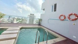A rooftop pool with a view of the cityscape, a lifebuoy, and a water slide. - Exclusive 3 Bedroom Apartment - Sunset 47 (Cartagena)