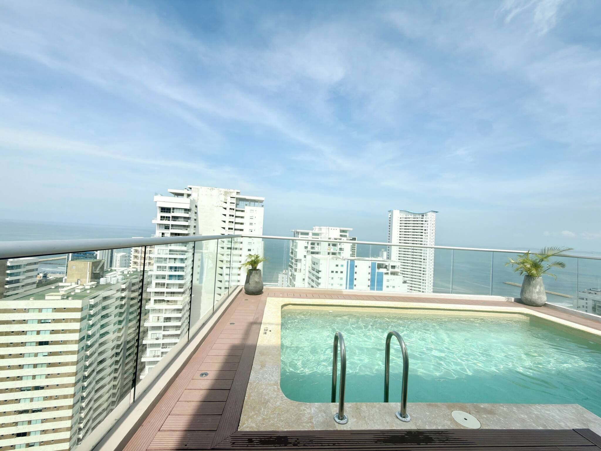 Piscina en la azotea con vistas despejadas a edificios altos y al océano.