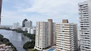 A high-rise building with multiple balconies and a river in the background. - Exclusive 3 Bedroom Apartment - Sunset 47 (Cartagena)