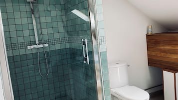 Een douche, handdoeken, zeep, toiletpapier