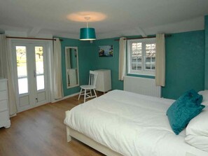A bedroom with a bed, a chair, a desk, and a window. - Old Lyn Cottage (Lynmouth)