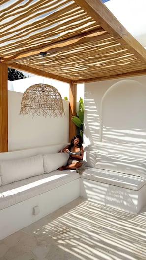 A sunlit outdoor seating area with a woven ceiling structure, a hanging light fixture, and a potted plant. - Designer 2BR Private Pool Villa Near Nyang Nyang Beach Uluwatu (kuta selatan)