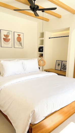 A bedroom with a bed, ceiling fan, wall-mounted shelf, and framed artwork. - Designer 2BR Private Pool Villa Near Nyang Nyang Beach Uluwatu (kuta selatan)