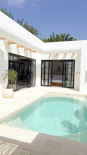 A modern house with a swimming pool, large glass doors, and a bedroom with a bed. - Designer 2BR Private Pool Villa Near Nyang Nyang Beach Uluwatu (kuta selatan)
