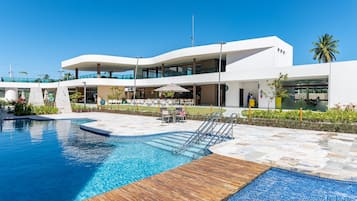 Um hotel moderno com piscina, área de estar externa e um pátio coberto.