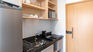 Uma cozinha moderna com forno embutido, cafeteira e micro-ondas na bancada.