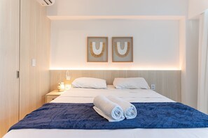 Habitación de hotel con cama, dos lámparas de pared y un adorno mural.