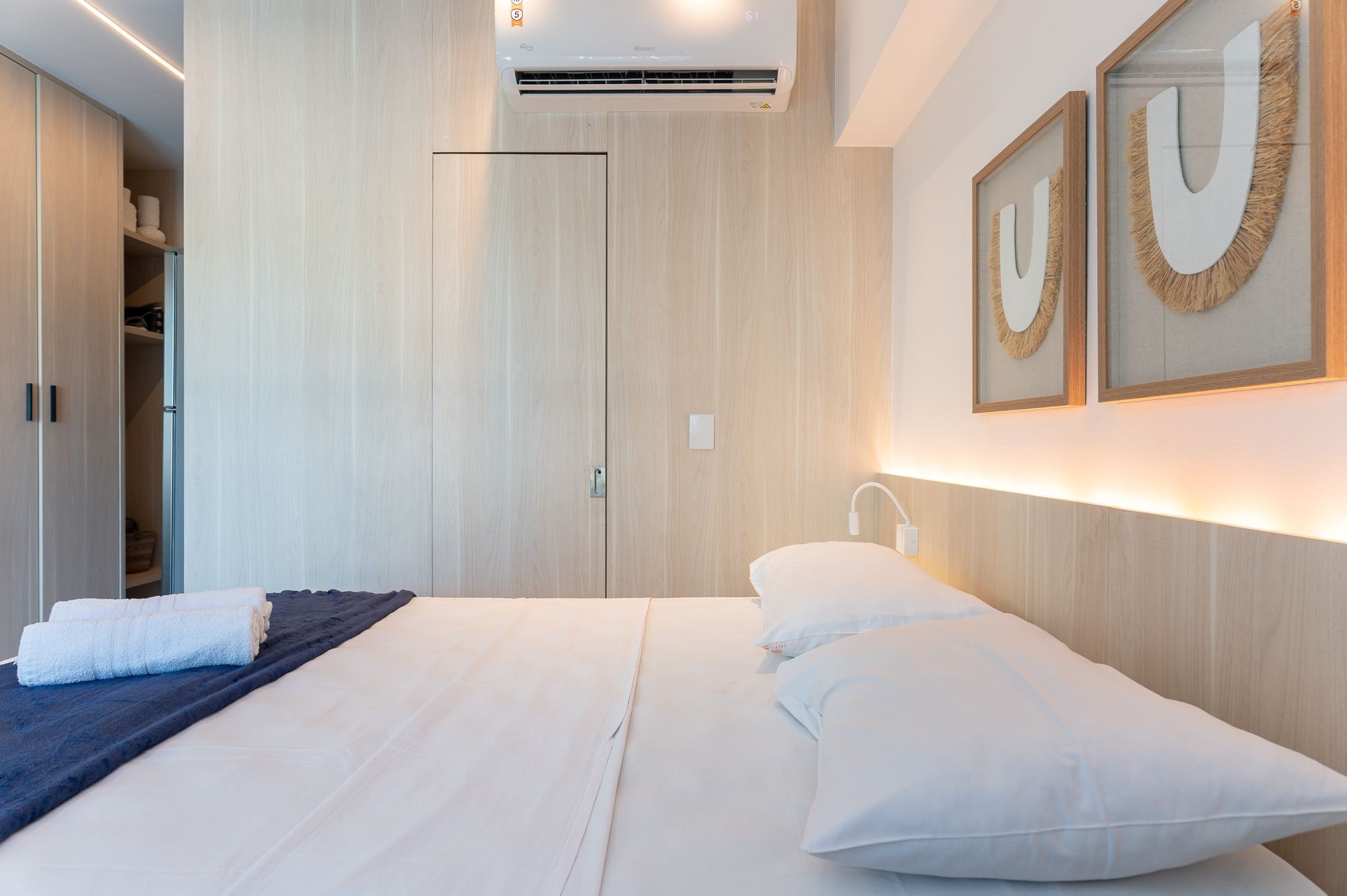 A modern bedroom with a bed, bedside table, and a wardrobe.