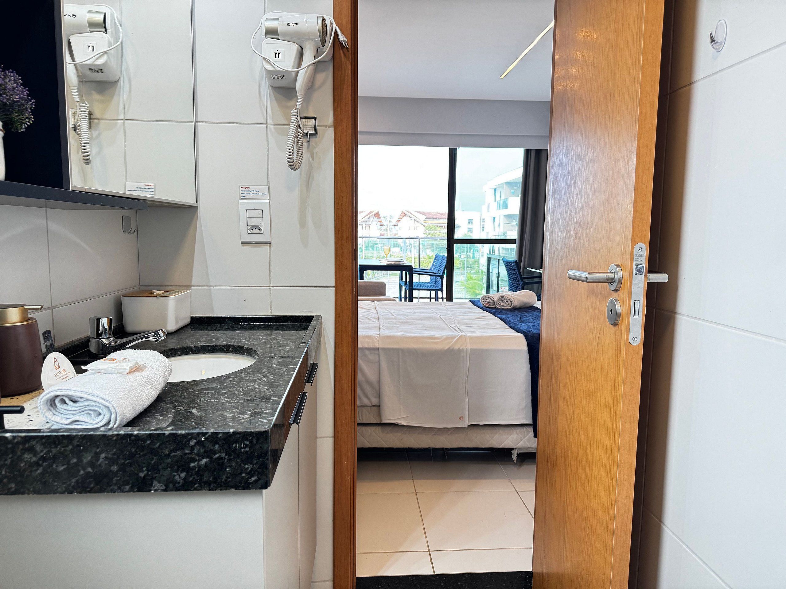 Une chambre d’hôtel avec salle de bain, un lit, une fenêtre et une vue sur l’extérieur.