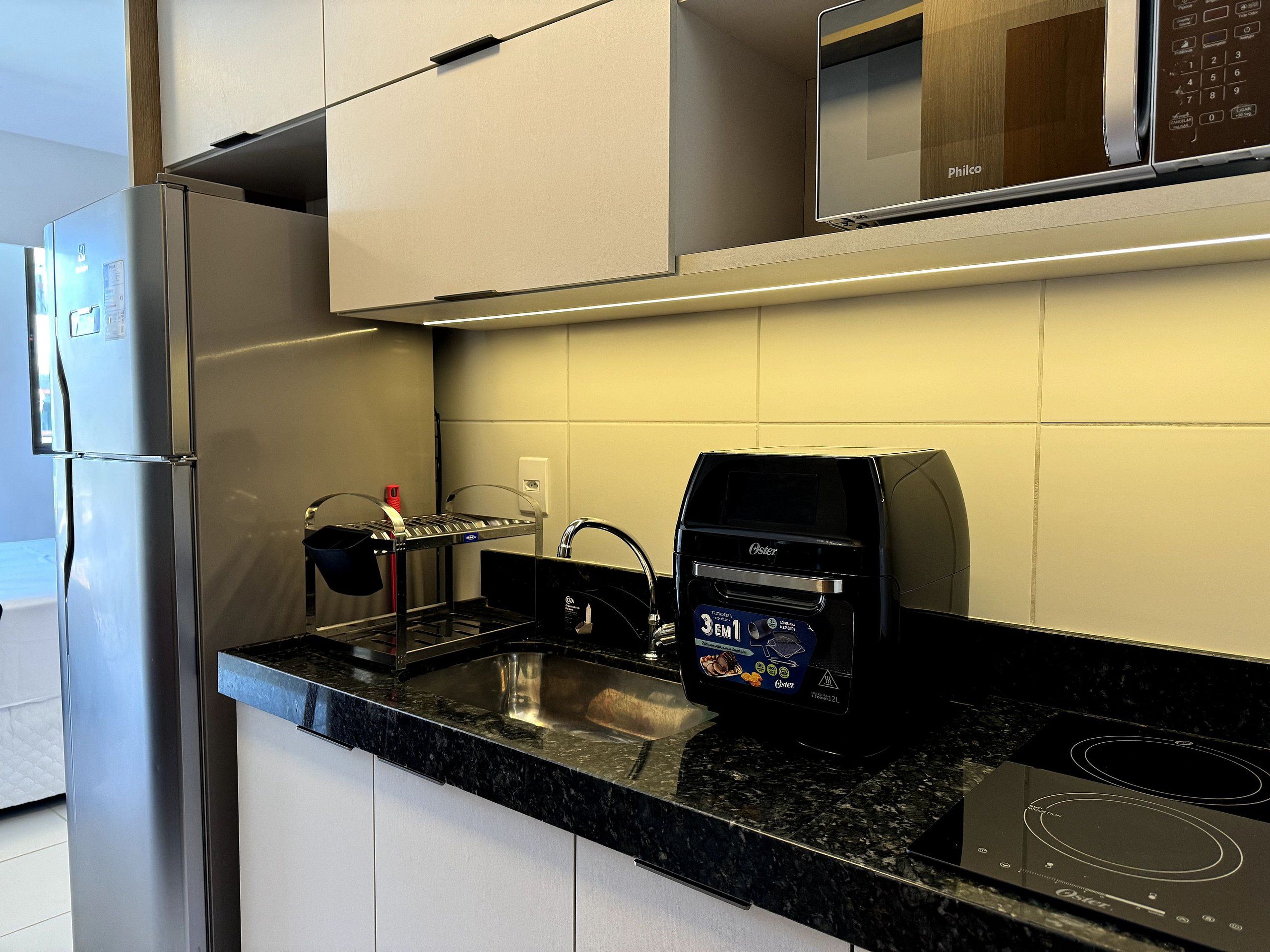 Una cocina moderna con horno empotrado, microondas y lavaplatos.