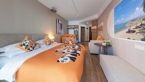 Quarto de hotel com cama, mesas de cabeceira, área de estar e uma janela grande com vista para a praia.