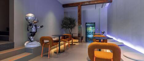 A modern interior with a robot figure, wooden furniture, and a large window.