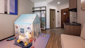 Ein modernes Wohnzimmer mit Spielbereich, inklusive eines kleinen Spielzeltes und einem Spielpferd.
