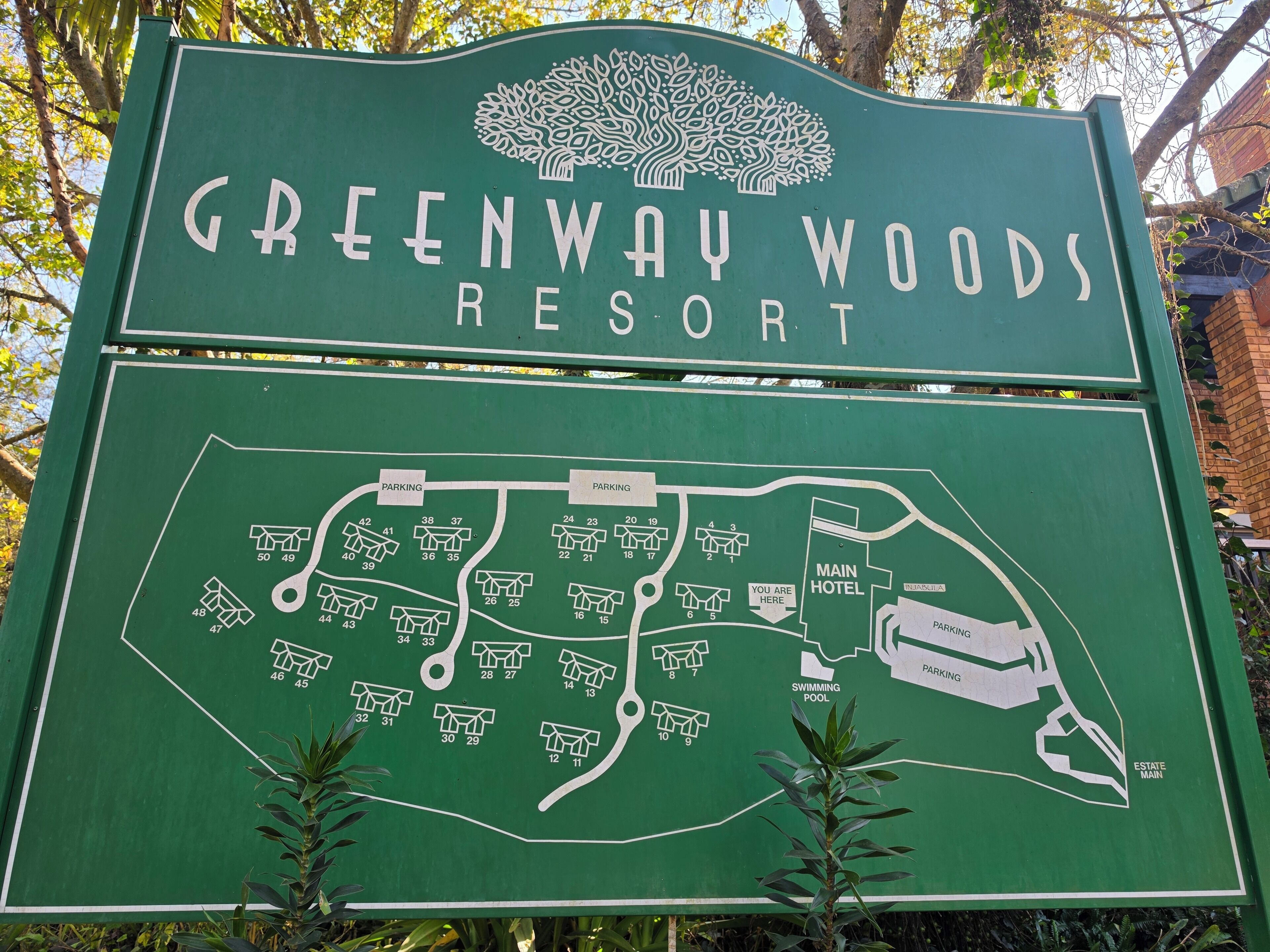 A sign for Greenway Woods Resort with a map indicating parking and hotel locations.