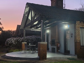 A modern building with a covered outdoor seating area, a brick facade, and a clear sky. - The Woods at Eleven (Mbombela)