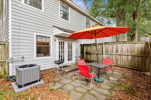 A patio with a table and chairs, an air conditioning unit, and a wooden fence. - Sea Gull Villa 8 Min Beach CHS (Mt Pleasant)