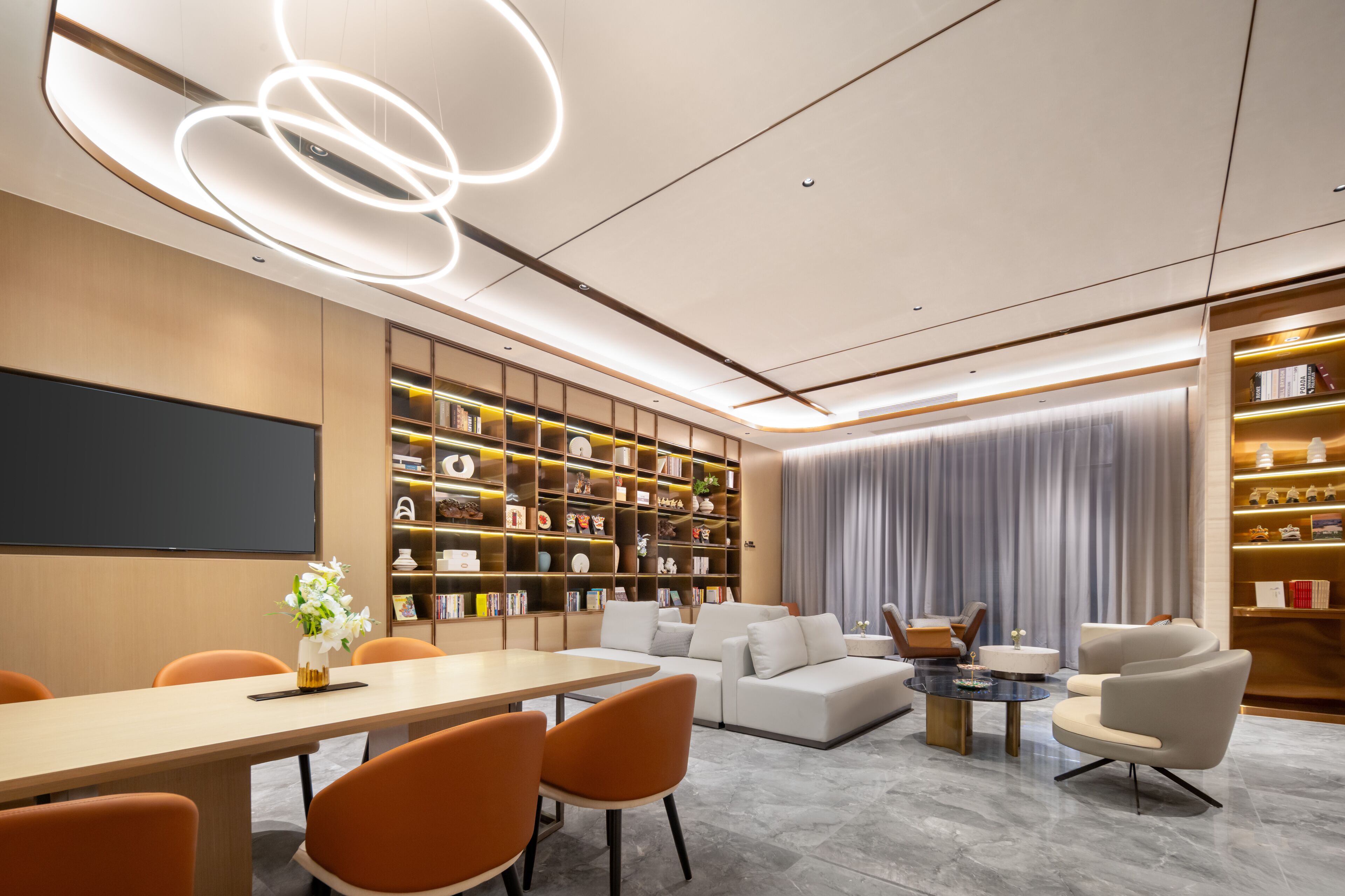 A modern interior with a dining area, seating, and a large bookshelf.