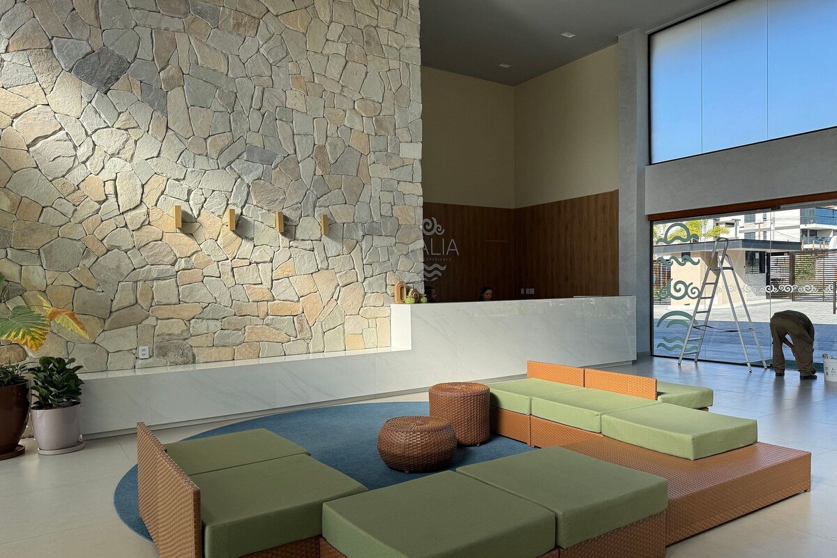 Eine moderne Lobby mit einer Steinwand, einer Sitzecke und einer Rezeption.
