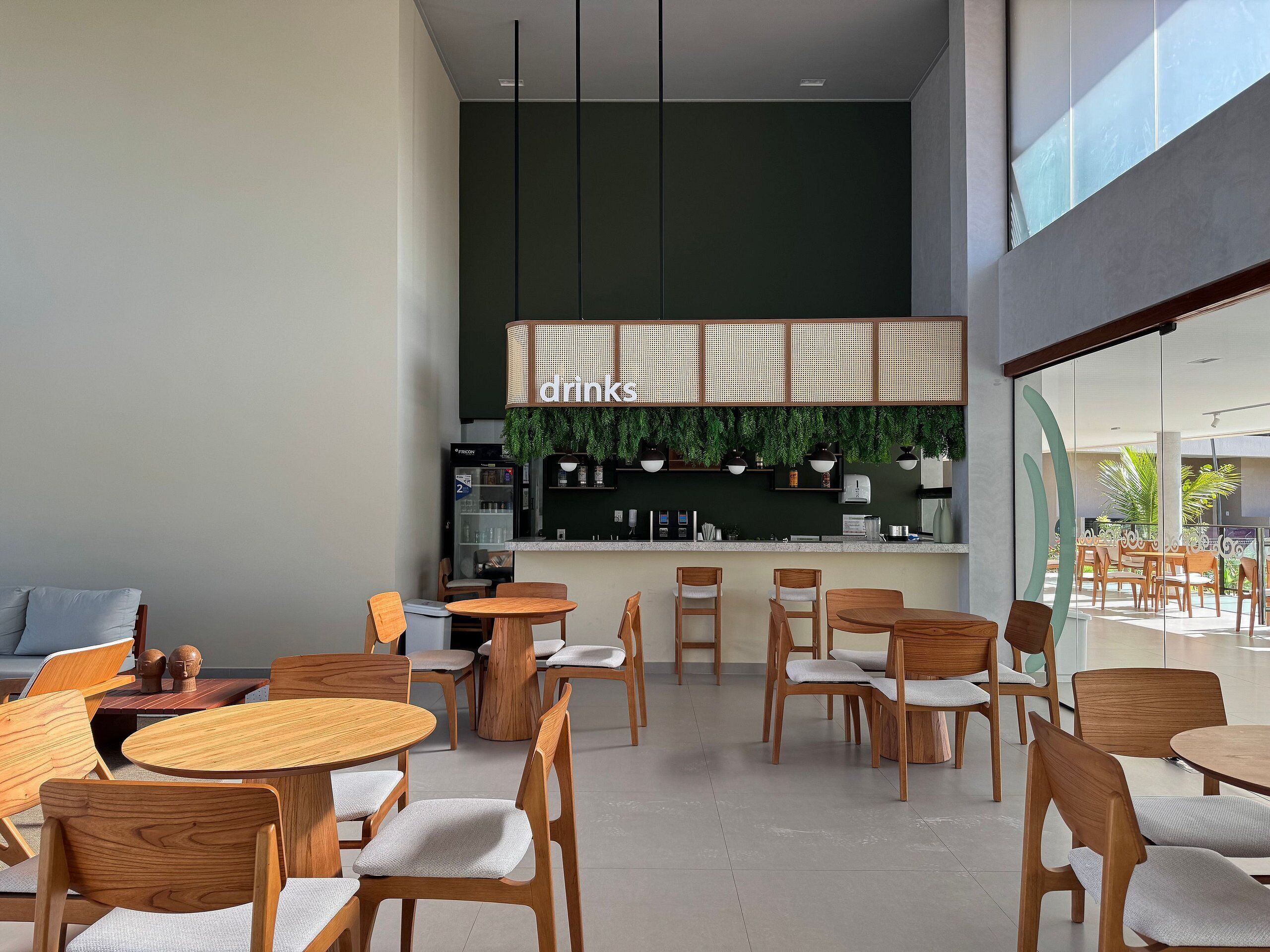 Interior de una cafetería moderna con mobiliario de madera y una zona de bar.