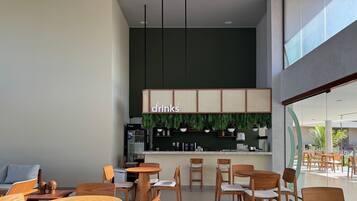 Interior de una cafetería moderna con mobiliario de madera y una zona de bar.