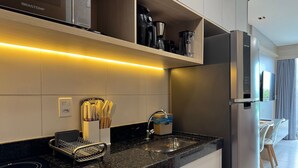 Een moderne keuken met een inbouwoven, een roestvrijstalen koelkast en een aanrecht met een messenhouder.