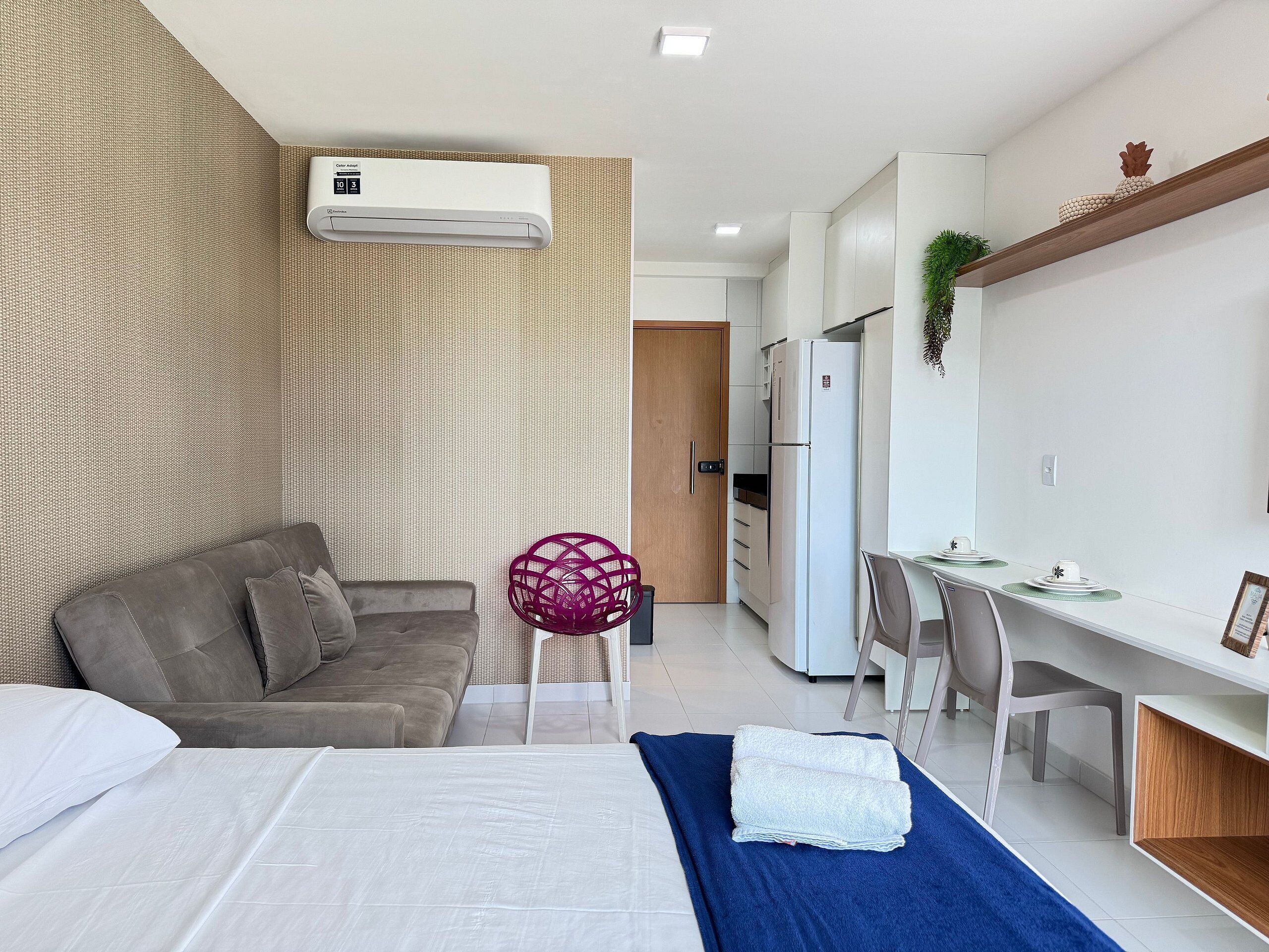 Un dormitorio moderno con cama, escritorio y kitchenette.