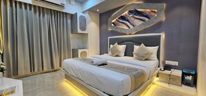 Un dormitorio moderno con una cama grande, cabecera con diseños geométricos y aire acondicionado integrado.