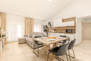 A modern apartment with a dining area, kitchen, and living space. - Apartment Le Cèdre  by Sur la mer (Le Muy)