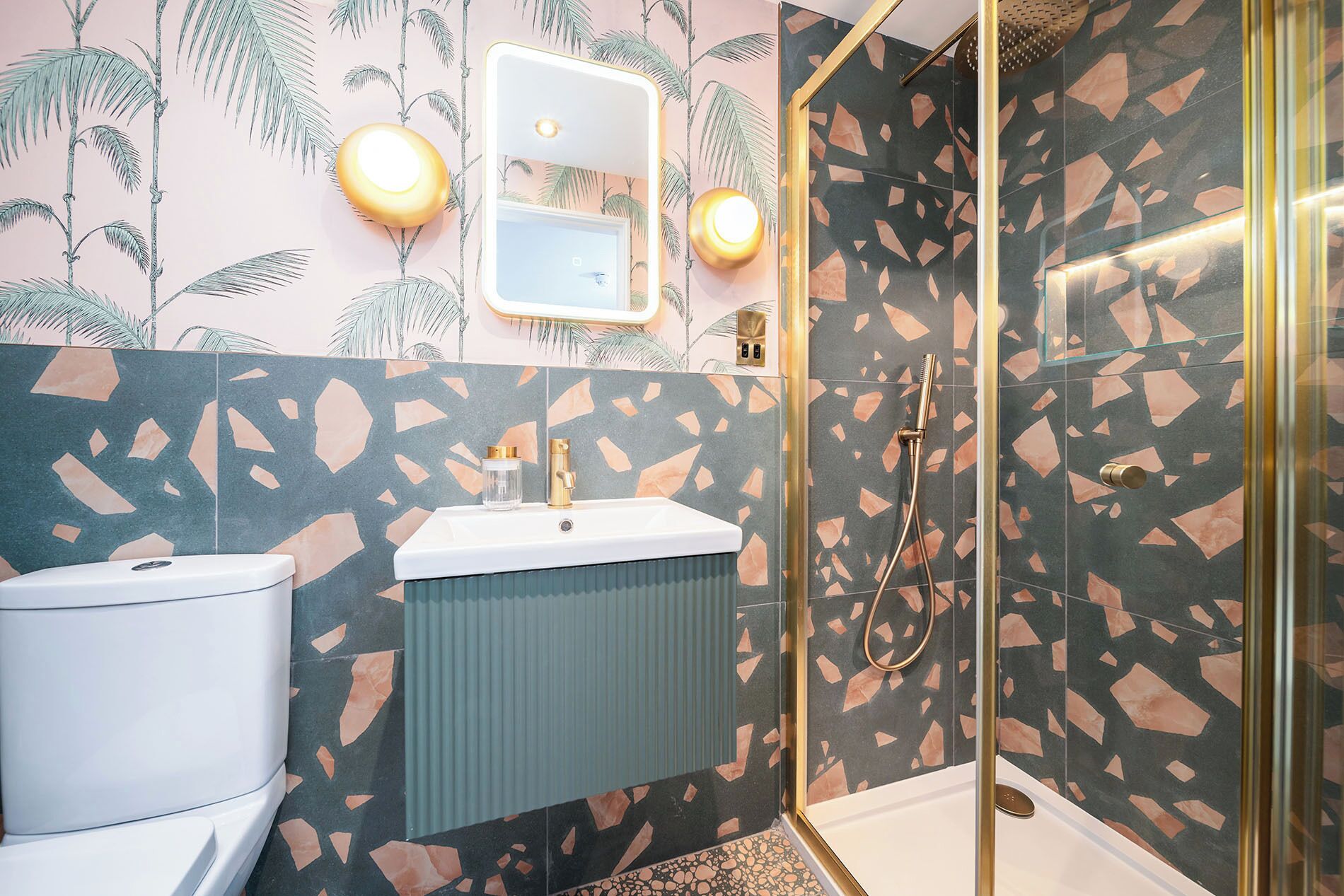 A bathroom with a toilet, sink, and shower area.