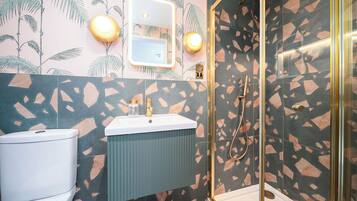 A bathroom with a toilet, sink, and shower area.