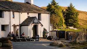 A building with a sign reading 'Kiristone Pass Inn' and a welcoming sign outside.