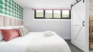 A bedroom with a bed, pillows, a window, and a sliding door.
