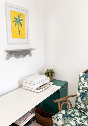 A room with a white desk, a framed picture on the wall, a green storage unit, and a chair with a floral pattern. - Welcome to Island Breeze, Your Oceanfront Escape in Beautiful St. Croix (Christiansted)