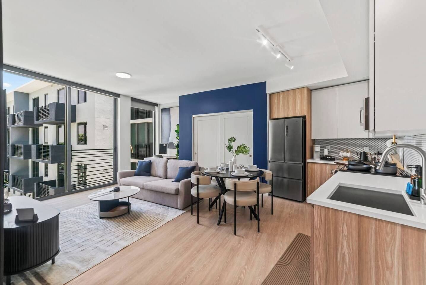 Bright modern living with open kitchen, dining, and courtyard views