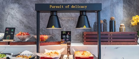 A buffet setup with a sign reading 'Pursuit of delicacy,' featuring various food items and condiments.