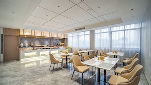 A modern hotel dining area with a central buffet, multiple tables, and chairs. - Poltton International Apartment (Zhanjiang Xuwen Chengdong Dadao) (Zhanjiang)