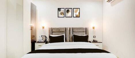 Un dormitorio moderno con una cama grande, mesitas de noche y una obra de arte colgada en la pared.