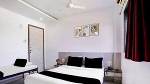 A modern hotel room with a large bed, bedside tables, a desk, and a ceiling fan.