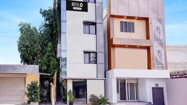A modern hotel building with a prominent 'HOTEL' sign, a two-story structure, and a gated entrance.