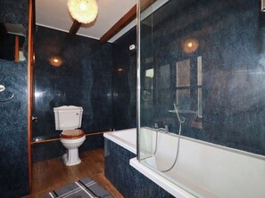 A modern bathroom with a toilet, bathtub, and shower. - Honeysuckle (Newquay)