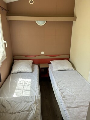 A small, compact room with two single beds, a window, and a door. - Le Cabanon des Étangs by Sur la mer (Fréjus)