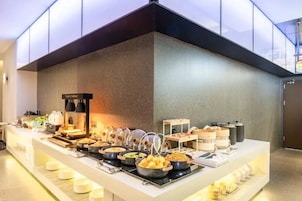 A buffet setup with various food items and a coffee station.