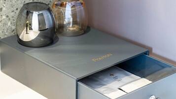 A metallic object with the word 'POLTON' on it, a transparent glass object, and a drawer with a visible lock mechanism.