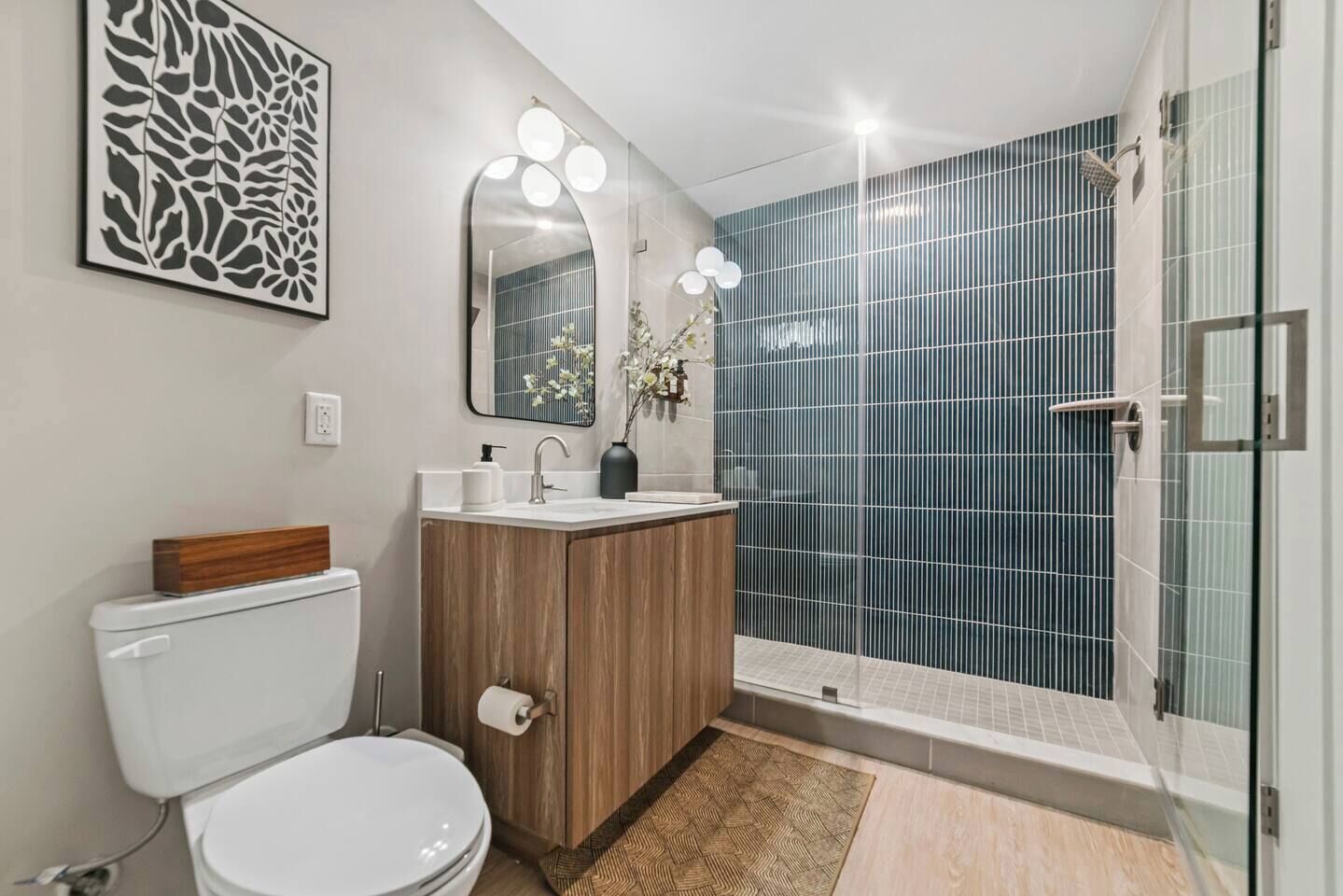 A modern bathroom with a toilet, sink, and shower.