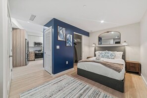 A modern bedroom with a bed, bedside table, and a mirror. - Close to Downtown FTL | Resort Style Pool | Free Parking | Gym | Dog Spa (Fort Lauderdale)