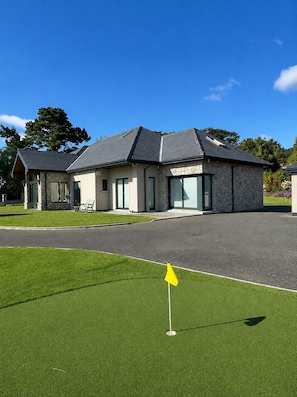 A building with a stone facade, large windows, and a paved driveway. - Spacious Coastal Family Retreat in Greystones (Greystones)