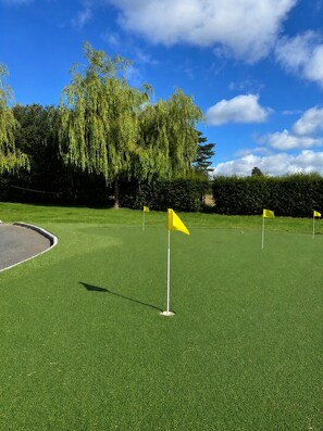 A golf course with artificial green turf and yellow flags marking the holes. - Spacious Coastal Family Retreat in Greystones (Greystones)